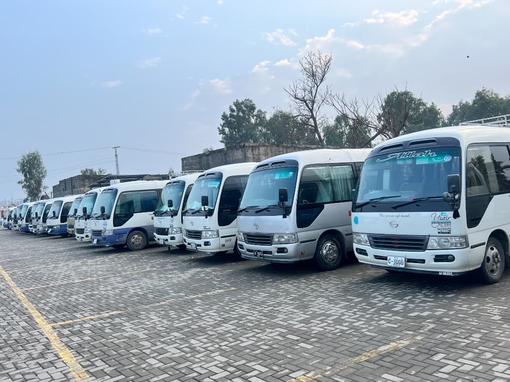 Usama Transport Solution Toyota Coaster fleet parked at the depot for institutional pick & drop services in Islamabad